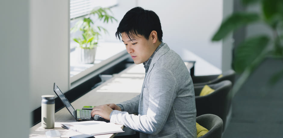 写真：窓側カウンター席で社員が仕事をしている様子