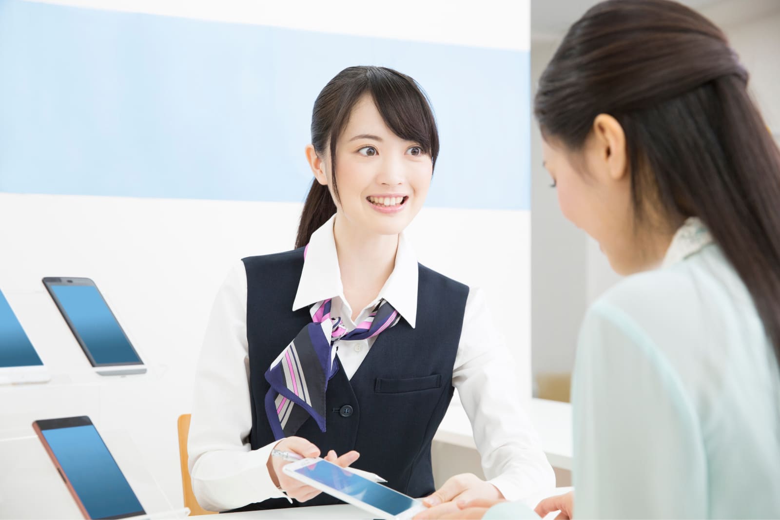 携帯電話ショップで接客している様子のイメージ写真。